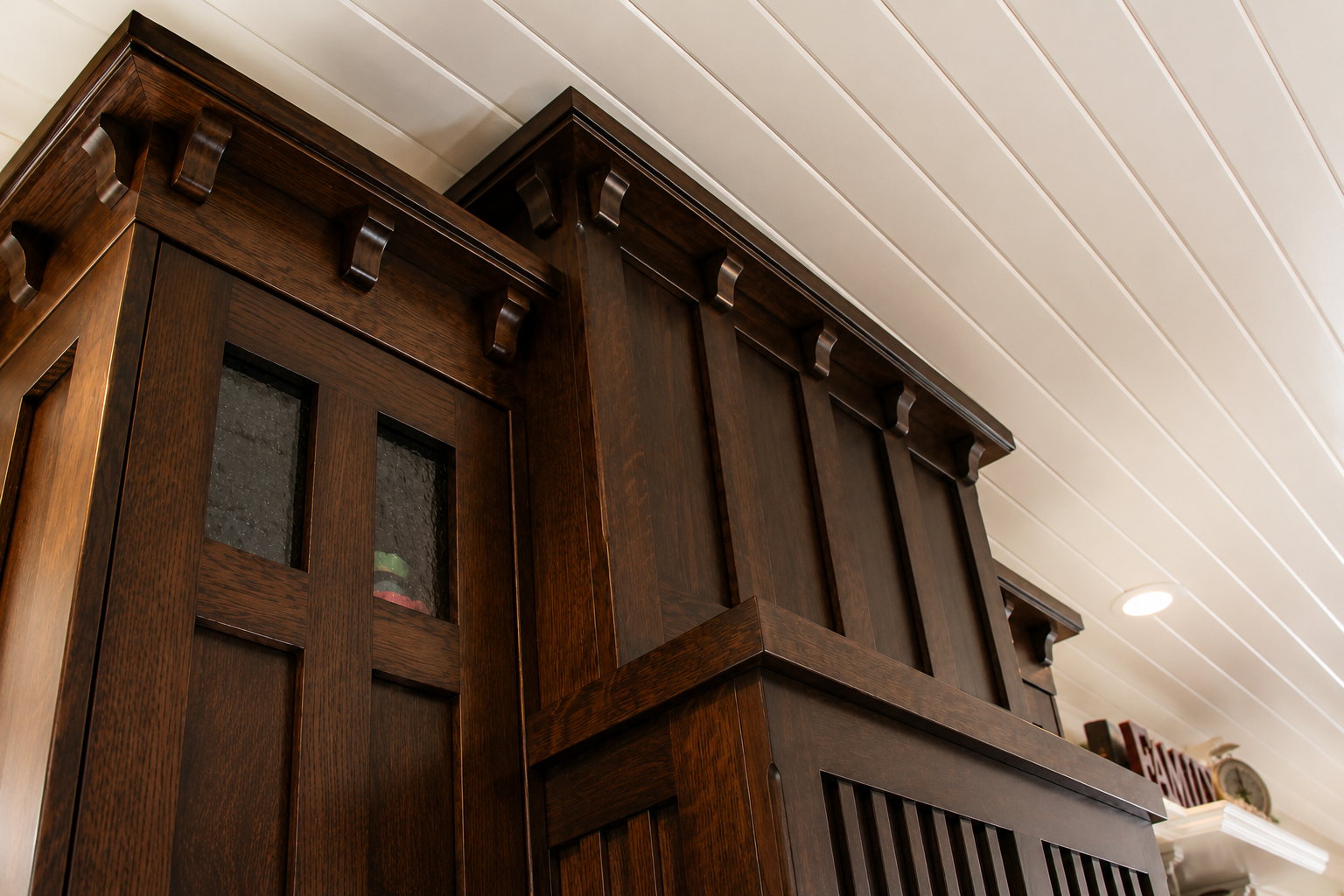 Handcrafted dark wood cabinetry with glass doors, custom trim and traditional detailing by Winters Woodworks.