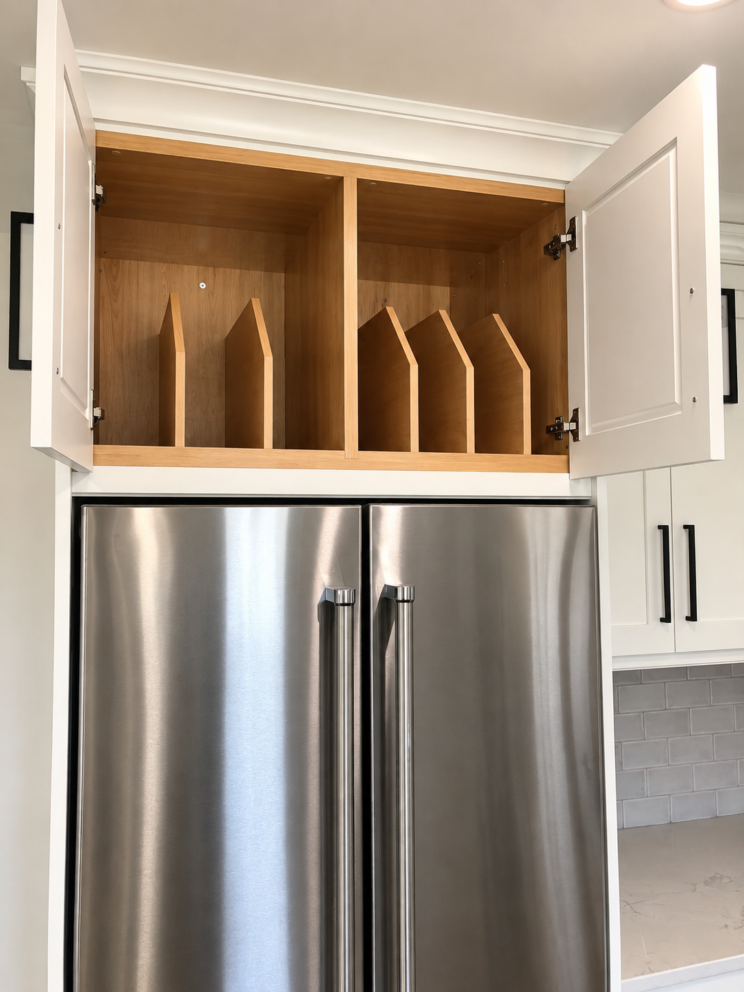 Custom cabinet above refrigerator with built-in wood dividers for organized vertical storage.