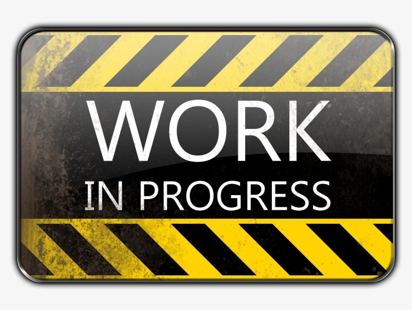 A warning sign with yellow and black caution tape design, reading 'Work in Progress' in large white letters.