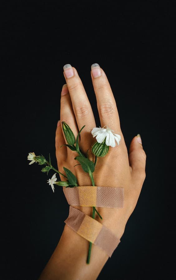 a hand with flowers and bandaides