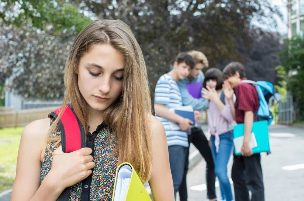 Young student looking anxious with group of students in the background