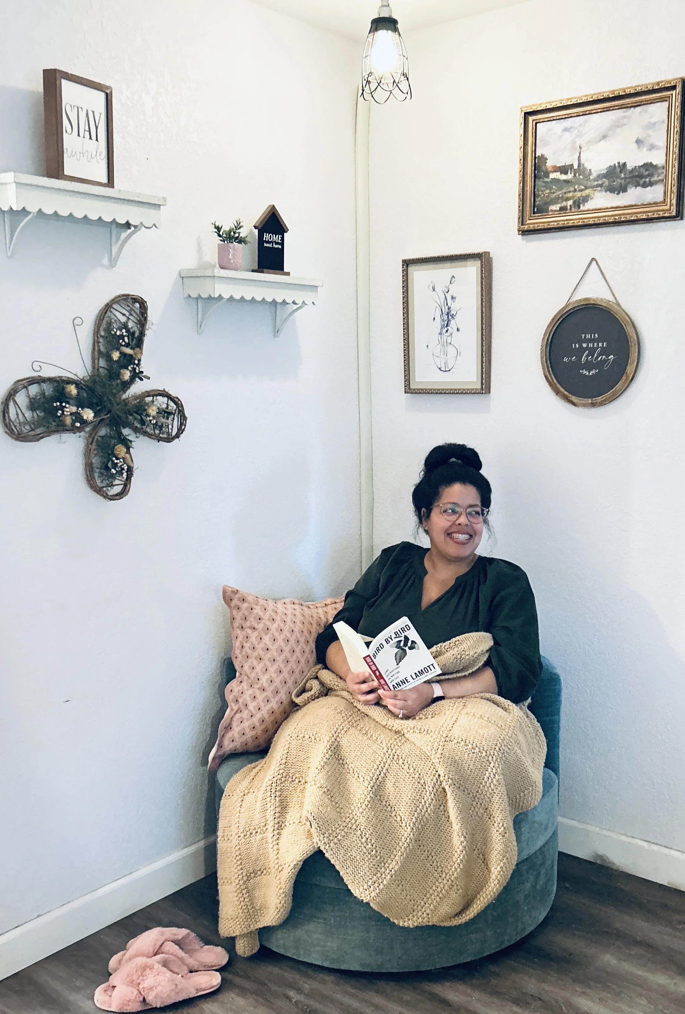 Woman on chair smiling with book. Cozy corner reading.