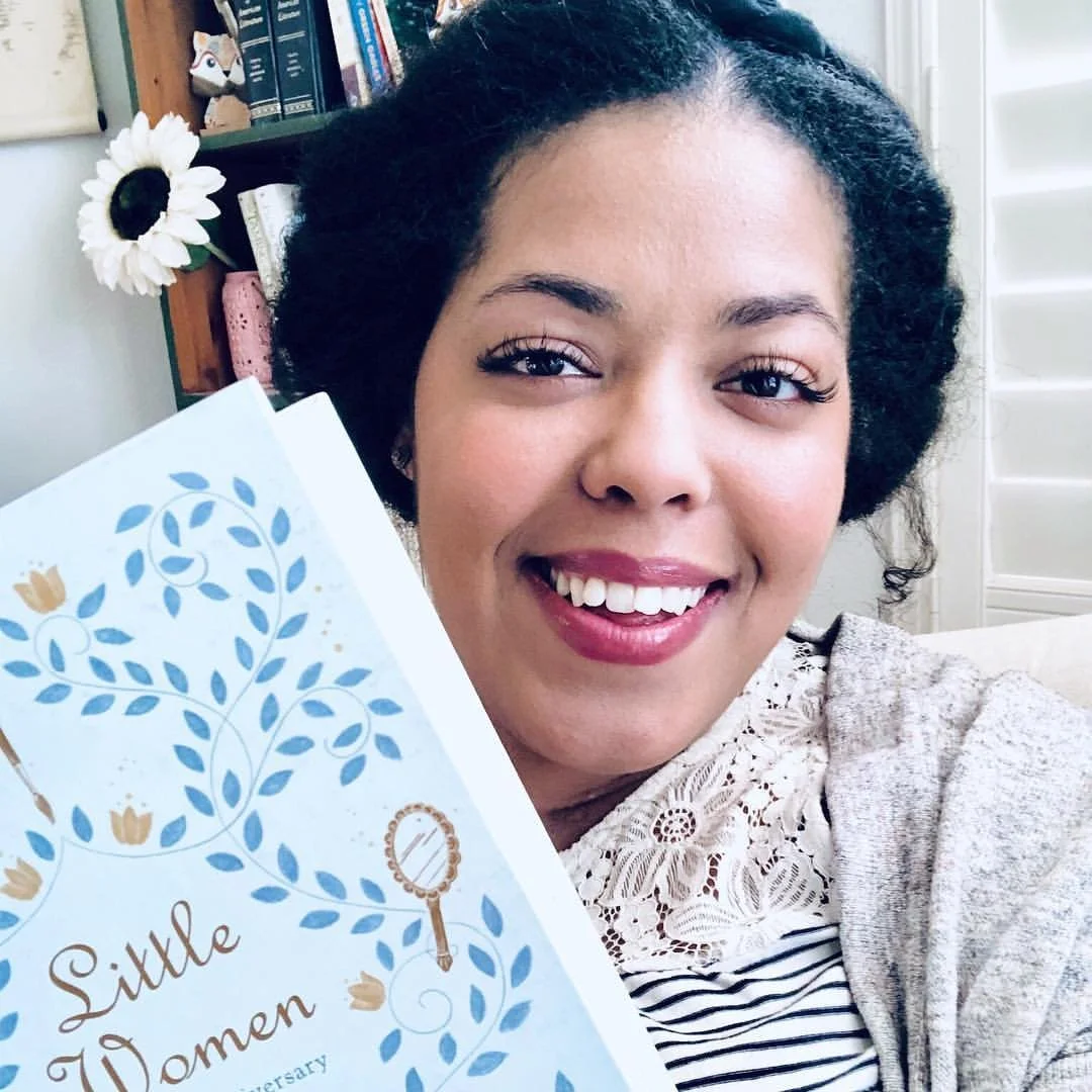 Renee smiling holding Little Women book