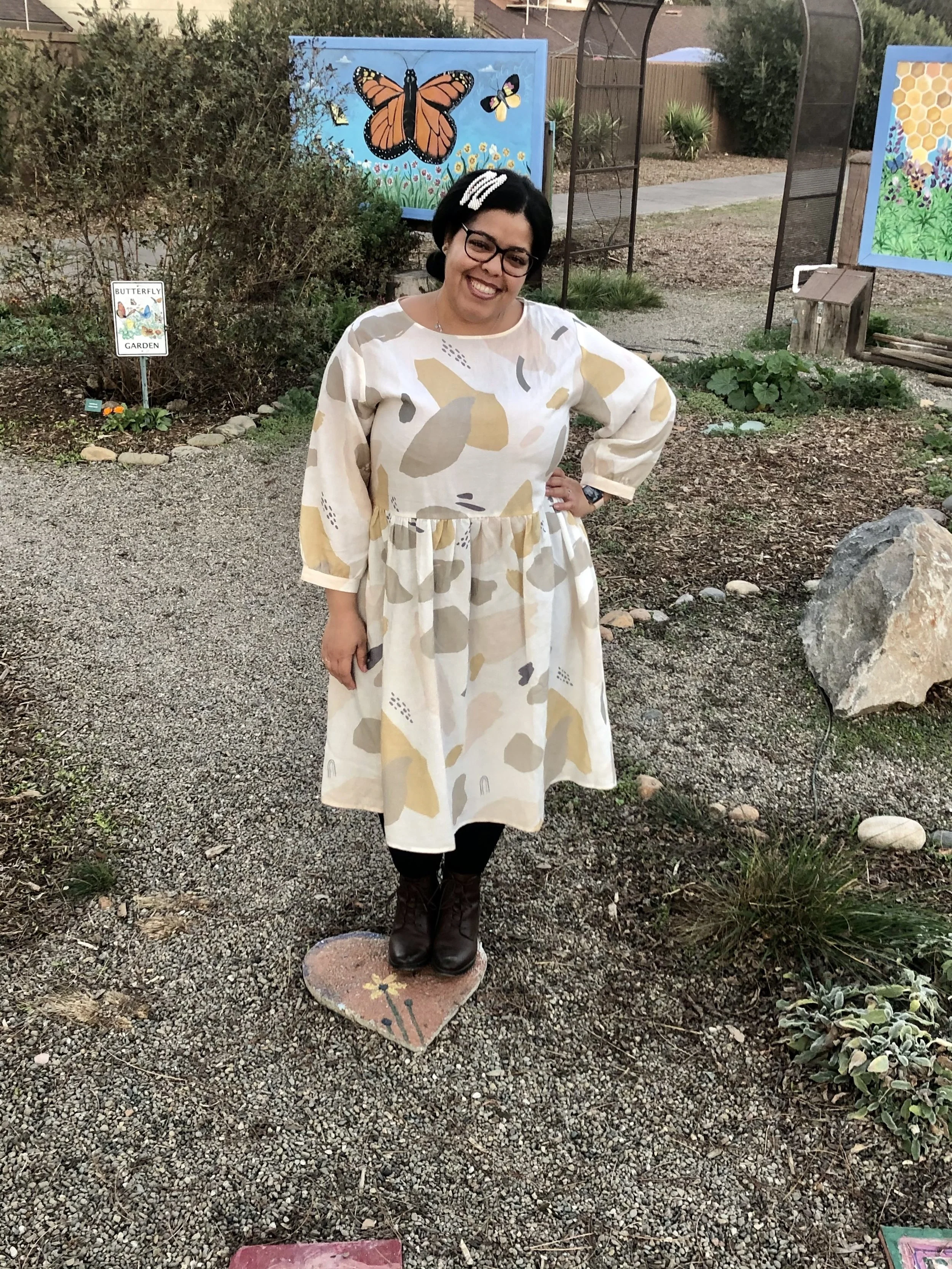Woman wearing boho dress on a rocky path in garden.