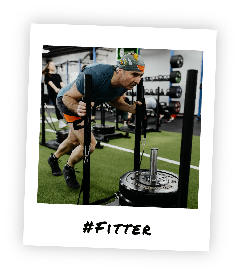 Mitglied beim intensiven Schlittenziehen im Kraft- und Ausdauertraining im Stil eines Polaroid-Fotos und dem Hashtag "Fitter" drauf geschrieben.