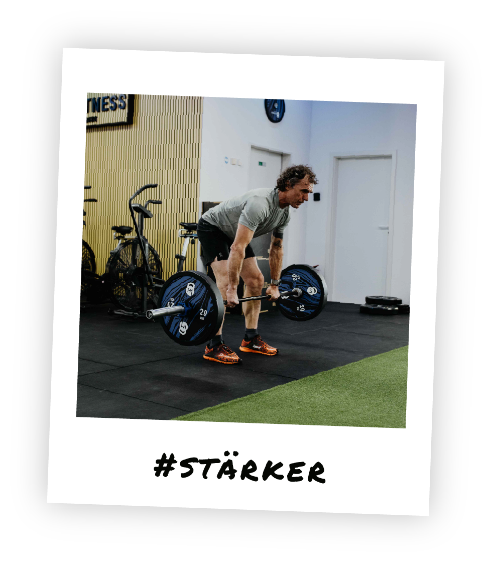 Functional Krafttraining bei HM Fitness – Mitglied beim Kreuzheben mit Langhantel für Muskelaufbau und Rückenkraft im Stil eines Polaroid-Fotos und dem Hashtag "Stärker" drauf geschrieben.