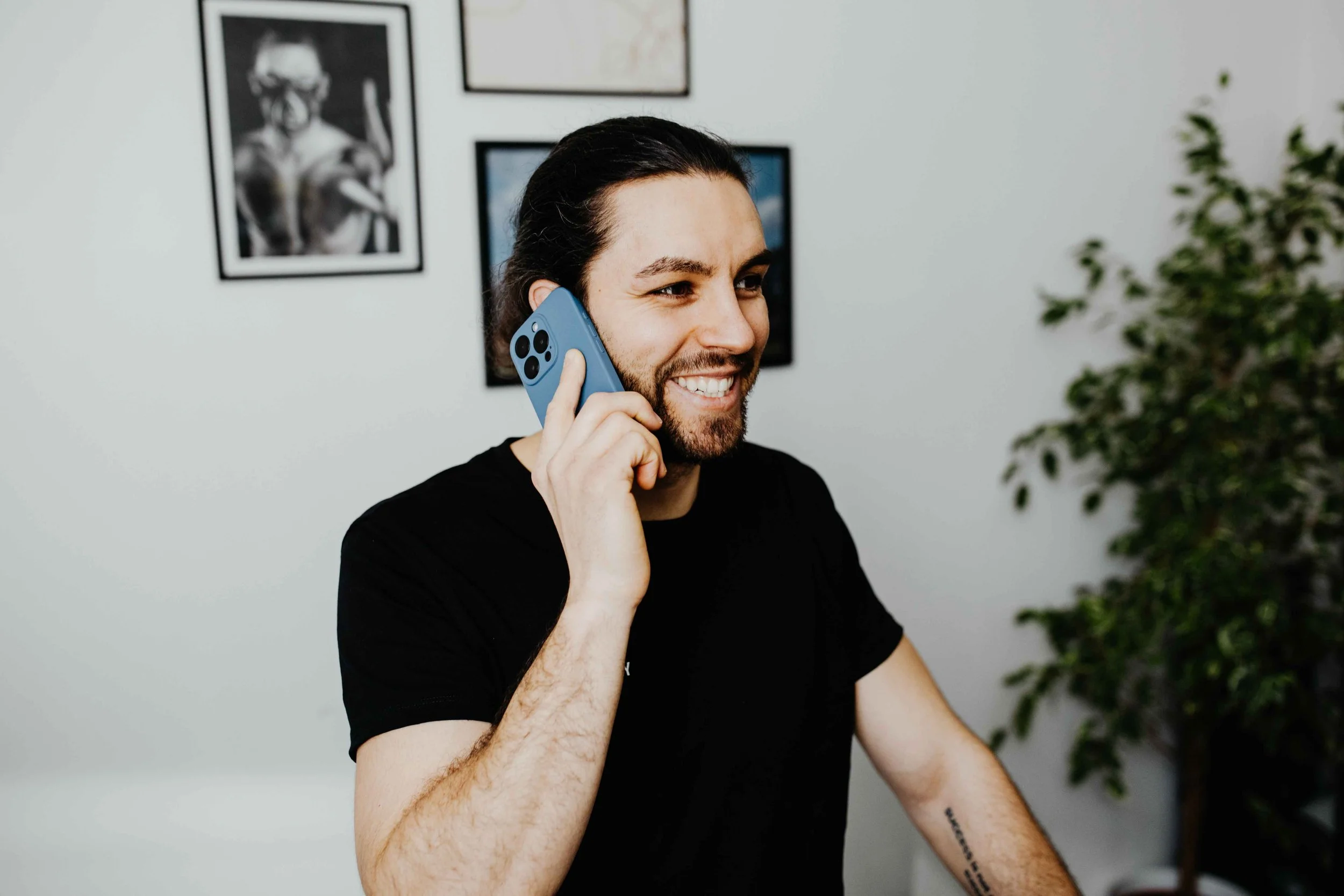 Coach Mury von HM Fitness führt ein freundliches Beratungsgespräch am Telefon im Büro.