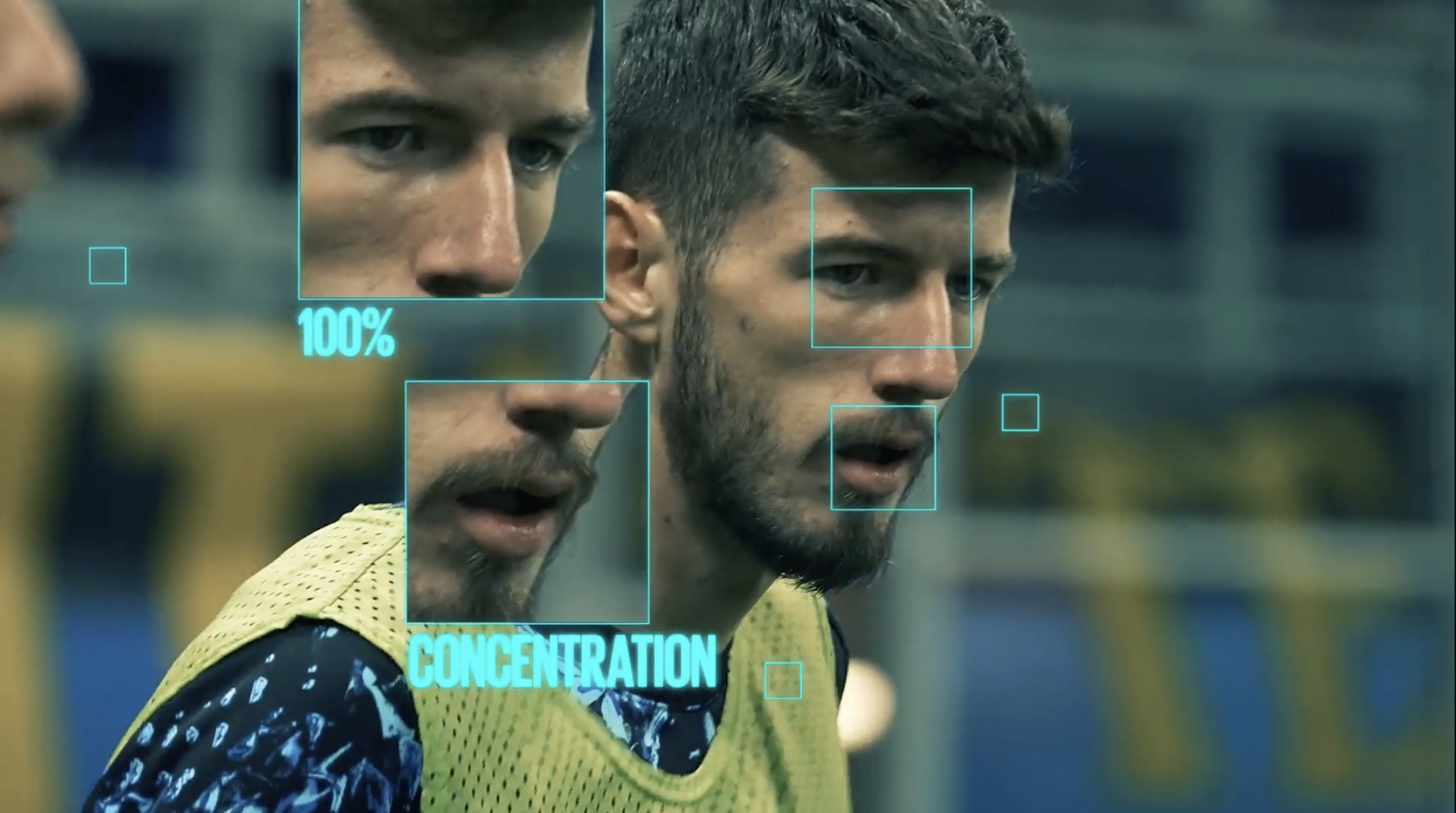 Due giovani uomini in allenamento con evidenziazioni di attenzione e concentrazione sul volto e sull'espressione, uno con barba cortissima e uno senza, in un ambiente sportivo.