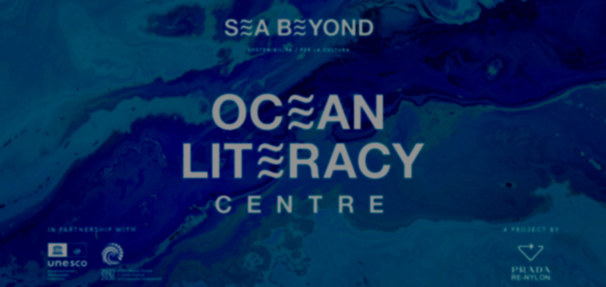 Logo del progetto Sea Beyond Ocea Literacy Center con sfondo blu e grigio, includente i loghi di UNESCO e Prada Re-Nylon.