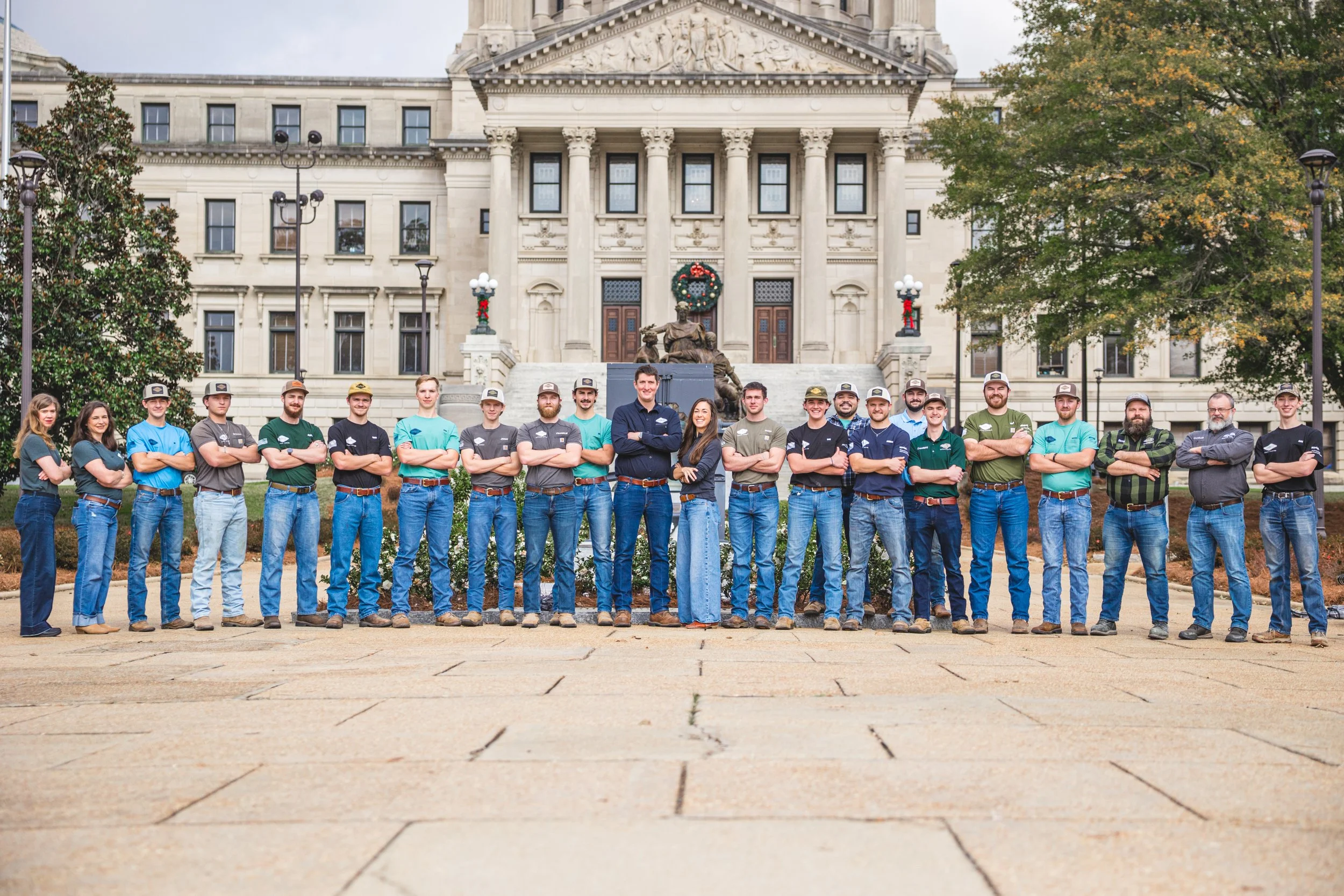 Group of people standing in front of a historic building, posing for a photo