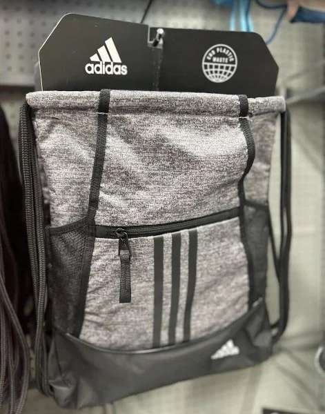 Adidas gray drawstring bag with black accents, zippered pocket, mesh sides, and End Plastic Waste sustainability tag.
