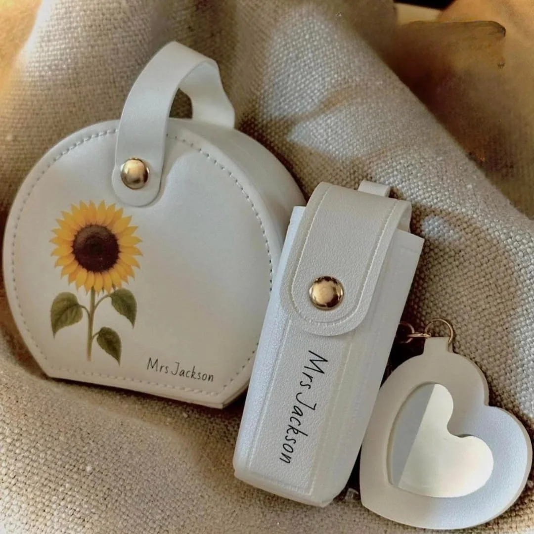 This personalized jewelry box set includes a circular case with a sunflower design, a rectangular holder, and a heart-shaped keychain, all elegantly crafted in white with gold accents and customized with 'Mrs Jackson.' Perfect for gifting or keepsake