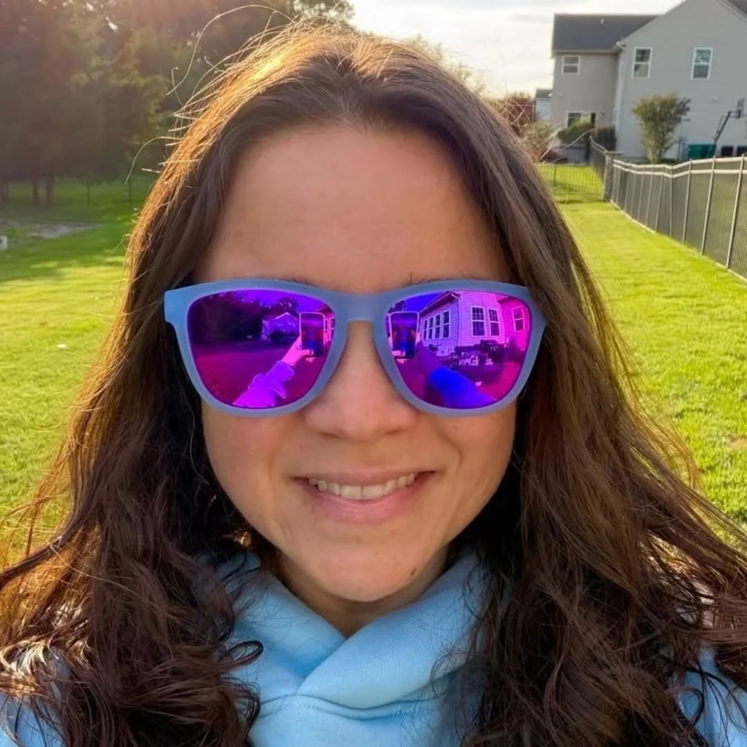 Nicole wearing Vivilook polarized sunglasses with pink mirrored lenses outdoors on a sunny lawn