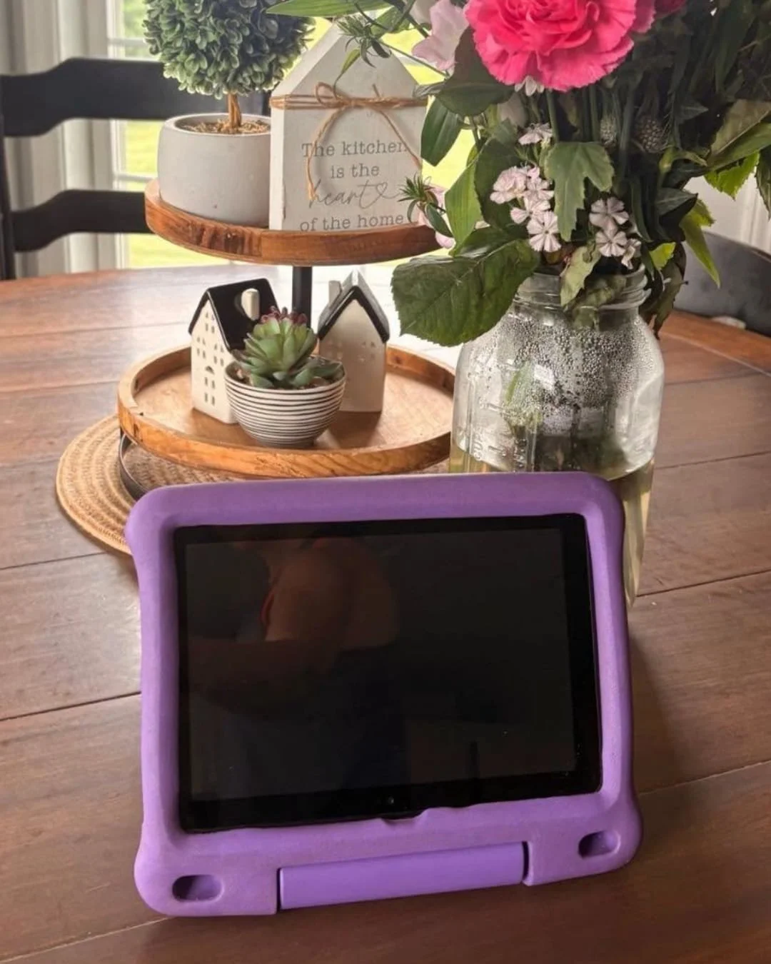 Amazon Fire 7 Kids tablet in purple protective case on wooden dining table