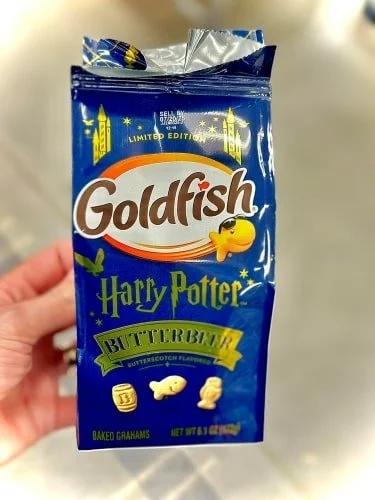 Limited edition Goldfish Harry Potter Butterbeer snack bag with dark blue packaging, featuring themed cracker shapes (barrel, goldfish, wizard hat) and butterscotch flavor.