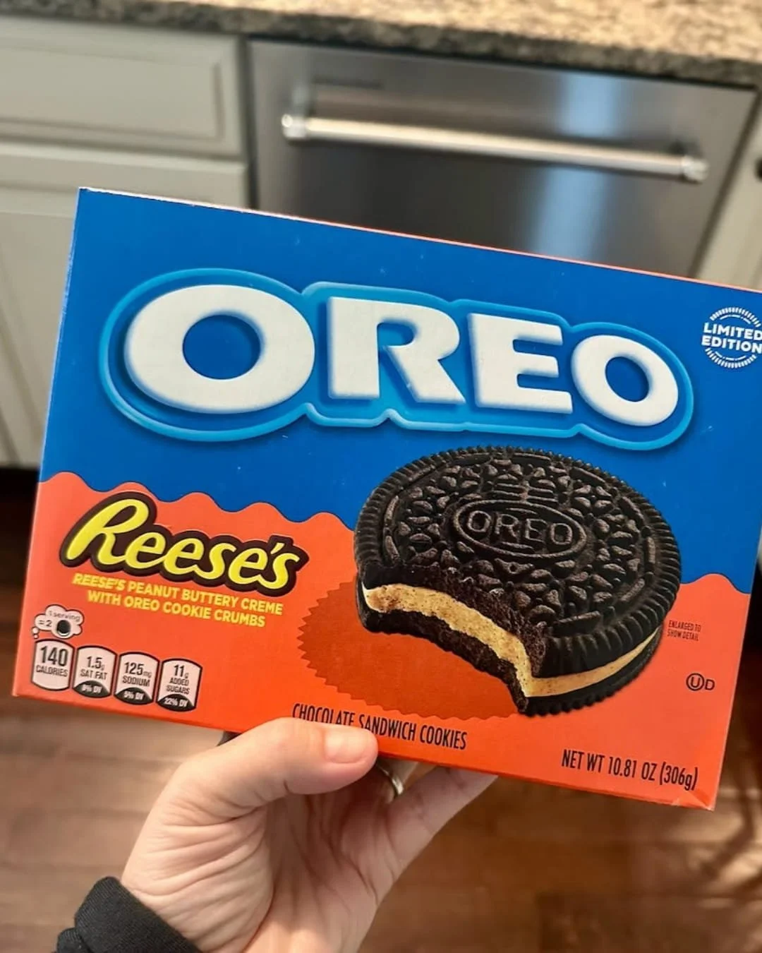 Box of limited edition Oreo Reese’s peanut buttery creme chocolate sandwich cookies held in a kitchen setting