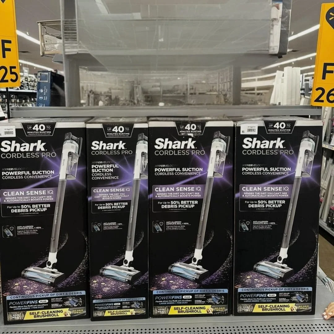 Shark Cordless Pro vacuum cleaner retail display showcasing features like 40-minute runtime, powerful suction, Clean Sense IQ, HEPA filtration, and self-cleaning brushroll.