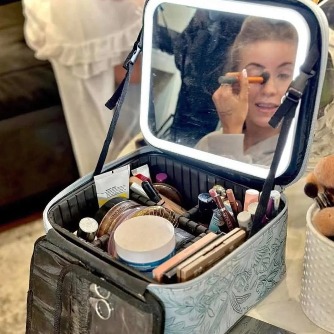 Light blue travel makeup bag with a floral pattern, LED-lit mirror, and organized compartments for cosmetics and skincare essentials. Perfect for on-the-go beauty.
