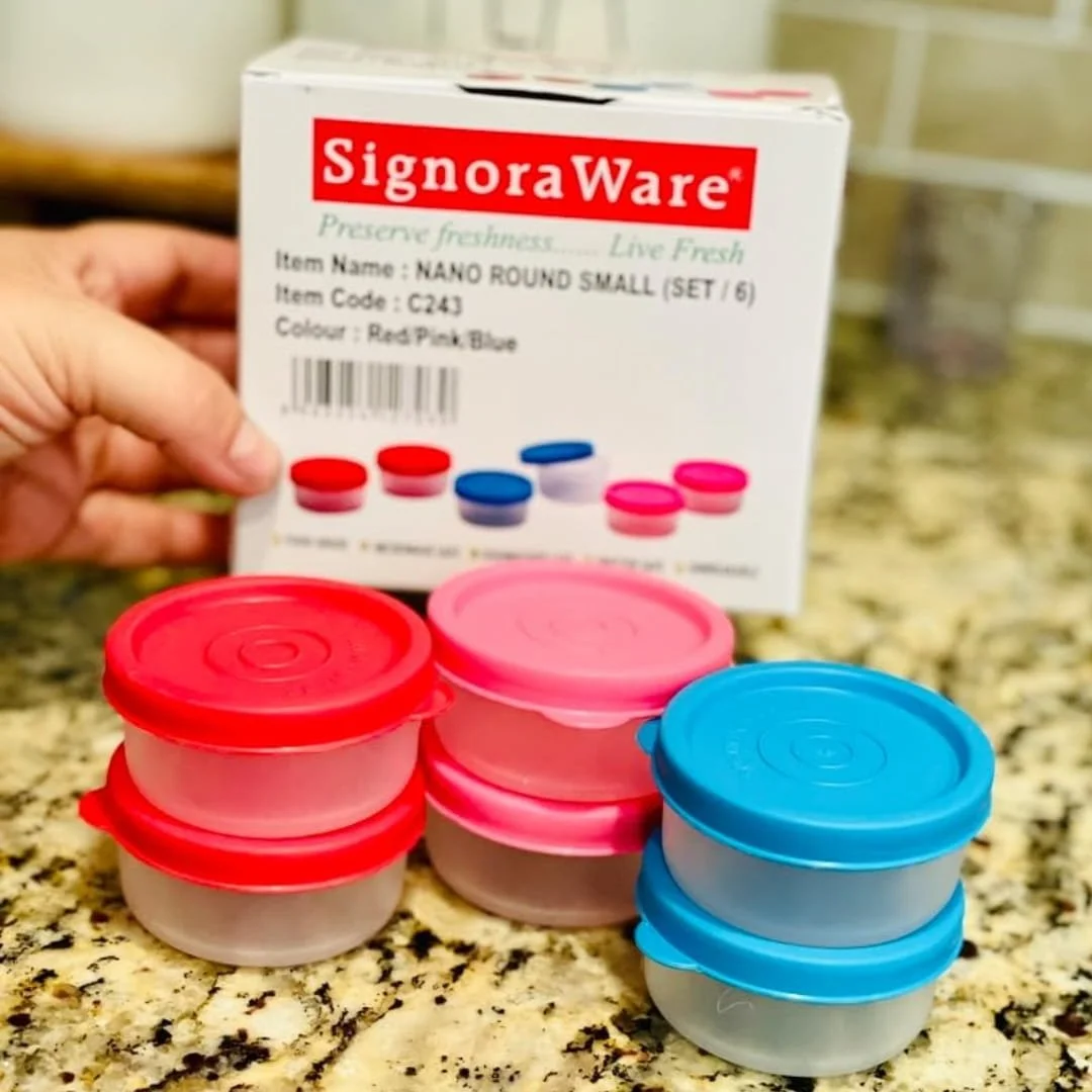 SignoraWare Nano Round Small condiment containers in red, pink, and blue lids, arranged in stacks on a granite countertop with the product box in the background.