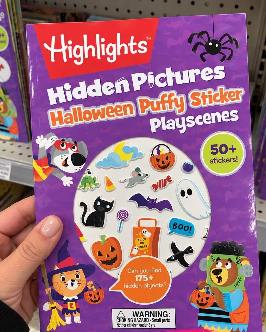 Hand holding a Highlights Hidden Pictures Halloween Puffy Sticker Playscenes book with colorful Halloween stickers on the cover