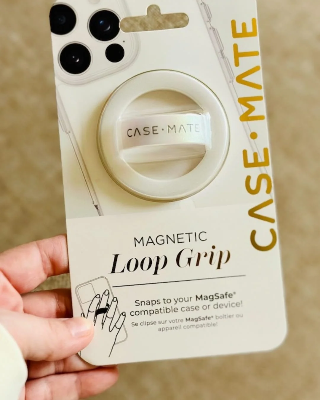 Case-Mate Magnetic Loop Grip packaging with a white circular base and iridescent loop strap, compatible with MagSafe devices, displayed on a sleek white and gold card.