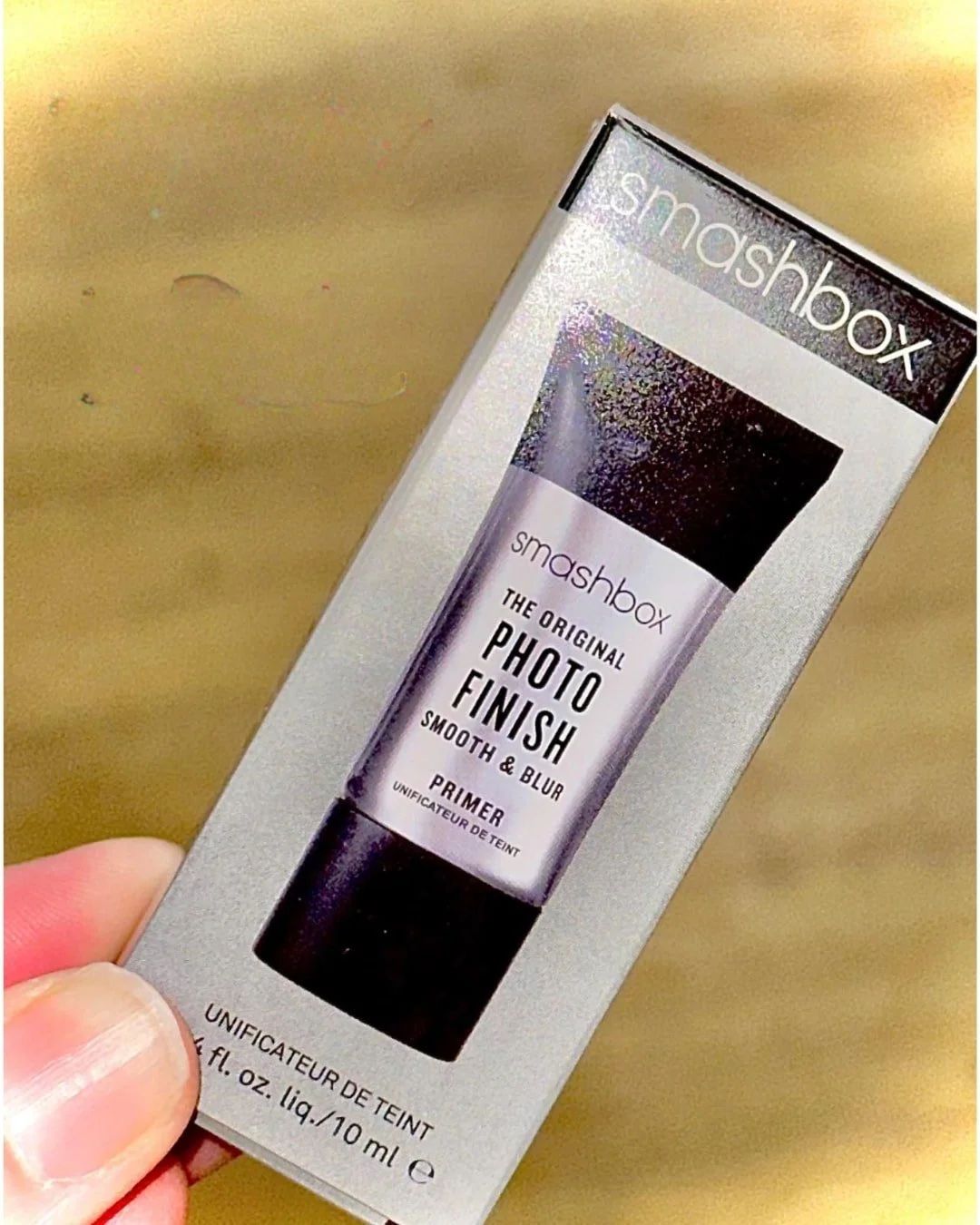 Smashbox Photo Finish Smooth & Blur Primer packaging held against a golden textured background.