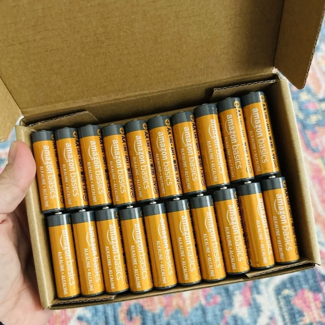 Open box of Amazon Basics AA alkaline batteries arranged in two neat rows inside cardboard packaging