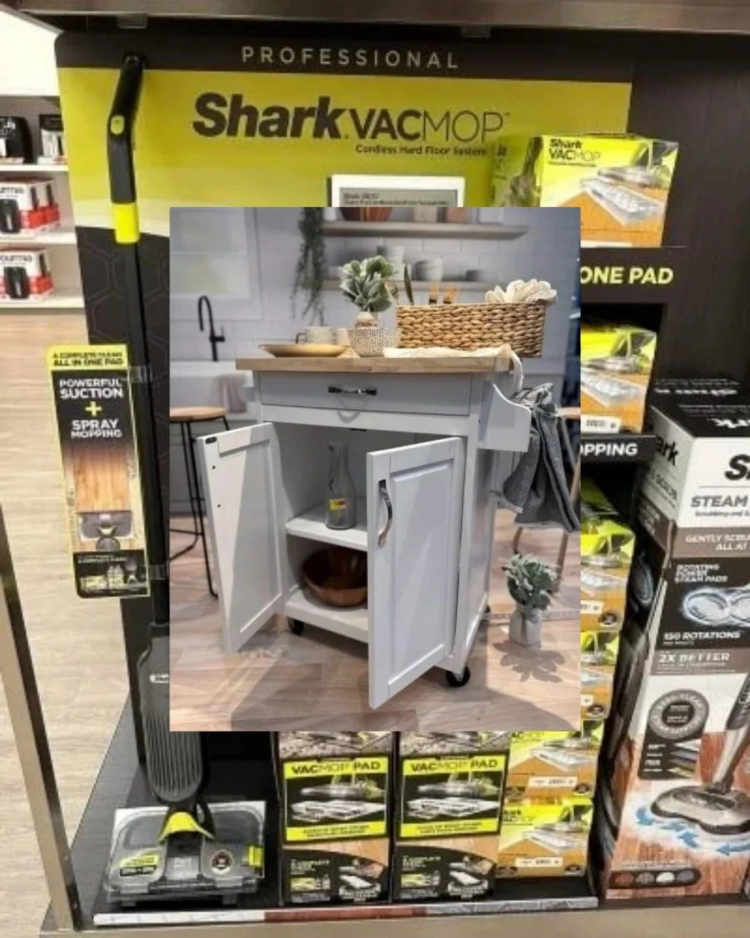 Retail display of Shark VACMOP and Steam Mop products, featuring promotional signage highlighting features like powerful suction, spray mopping, and 2X better cleaning, with an overlaid image of a modern kitchen island.