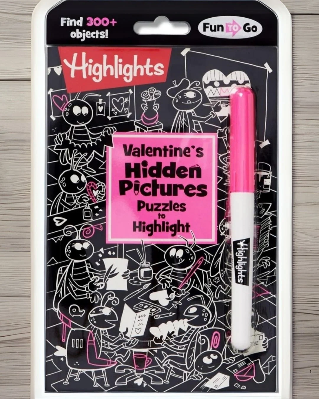 Highlights Valentine's Hidden Pictures Puzzles set, including a pink marker and bug-themed illustrations with hearts, flowers, and other Valentine's objects.