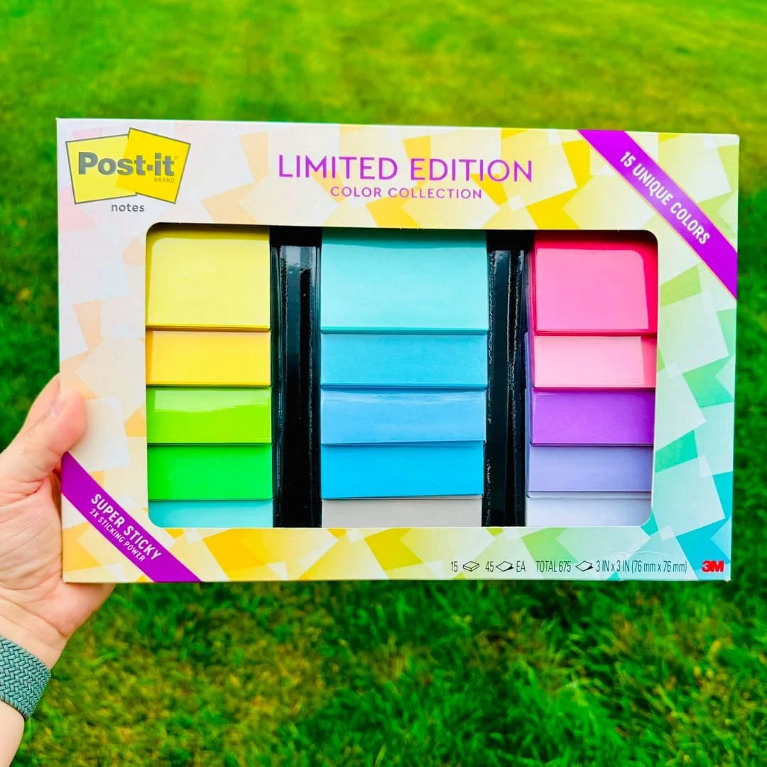 Hand holding a package of Post-it Super Sticky Notes limited edition color collection with 15 unique colors