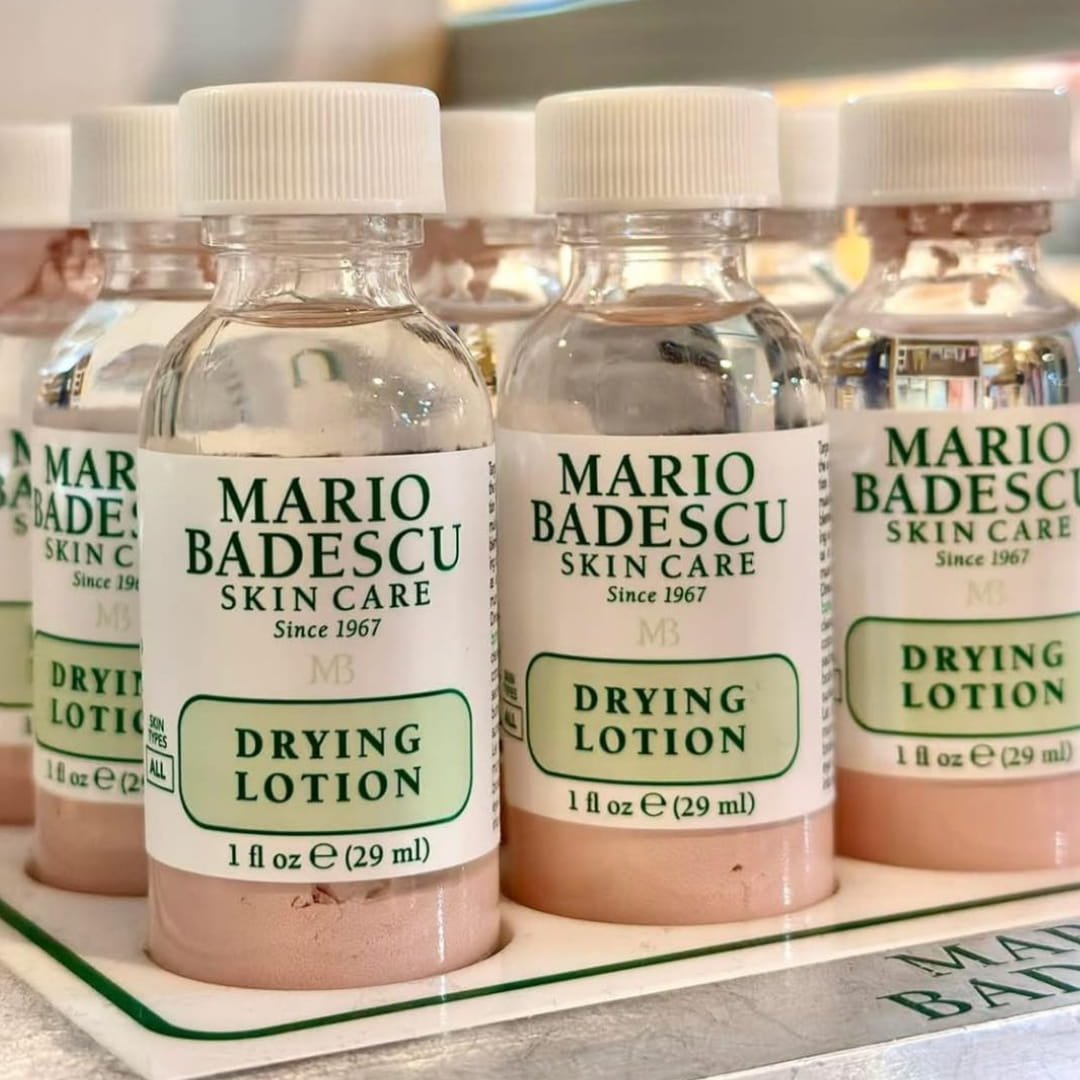 Mario Badescu Drying Lotion, a skincare essential since 1967, features a bi-phase formula with clear liquid and pink sediment. Perfect for spot treatment, it comes in a 1 fl oz bottle, elegantly displayed in a retail tray.