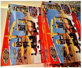 Children's construction toy set by FAST LANE, displayed in two boxes with a yellow crane, track system, and interactive features.