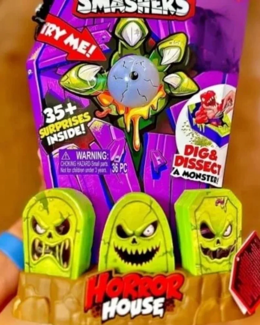 SMASHERS Horror House toy packaging with a monster hand, blue eyeball, and green tombstone toys, featuring 35+ surprises inside and Dig & Dissect a Monster text.