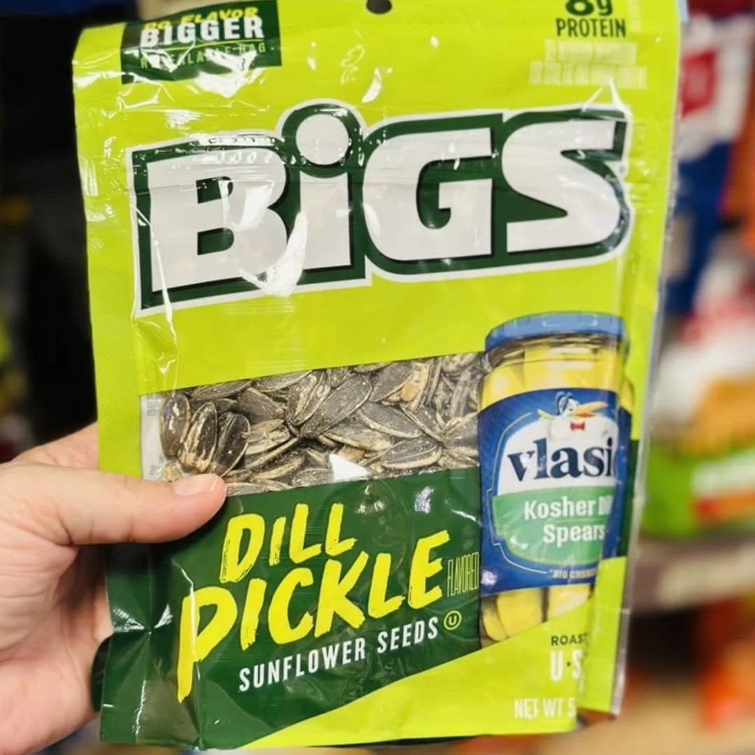 BIGS dill pickle flavored sunflower seeds bag with Vlasic pickle graphic held in store aisle