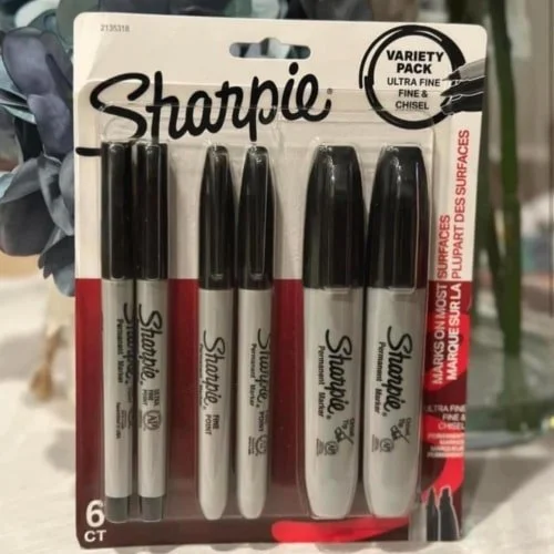 Sharpie Variety Pack with six black permanent markers, including Ultra Fine, Fine Point, and Fine & Chisel tips, displayed in clear plastic packaging with red and white branding.