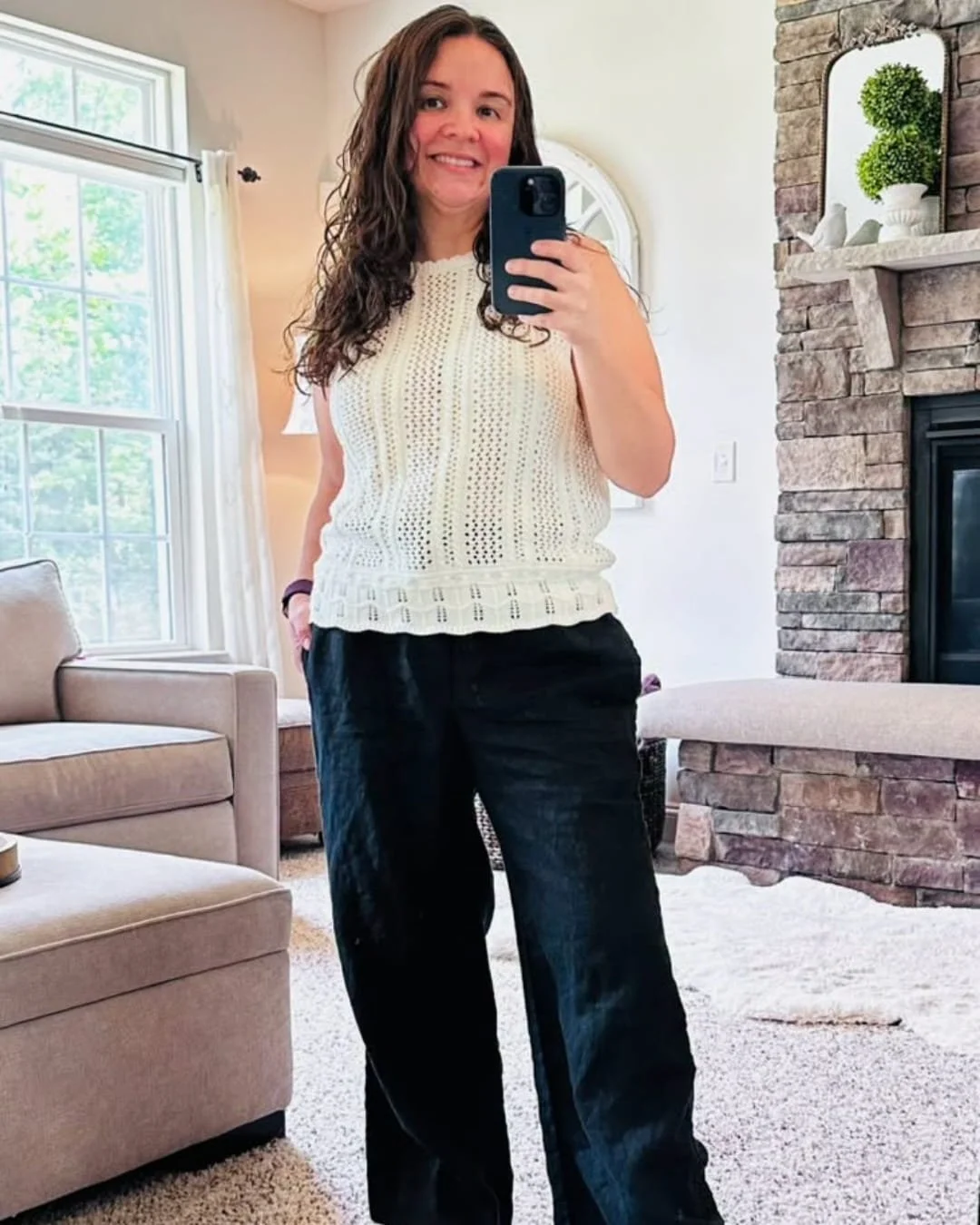Nicole wearing a KIRUNDO crochet sweater tank with black wide-leg pants in a bright living room mirror selfie