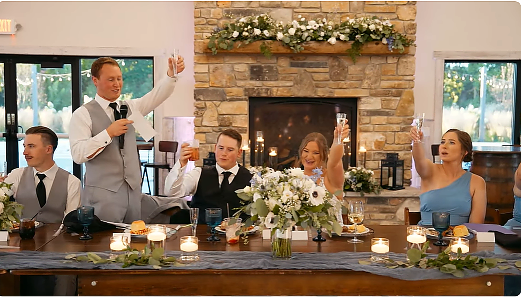 Wedding reception toast in front of stone fireplace