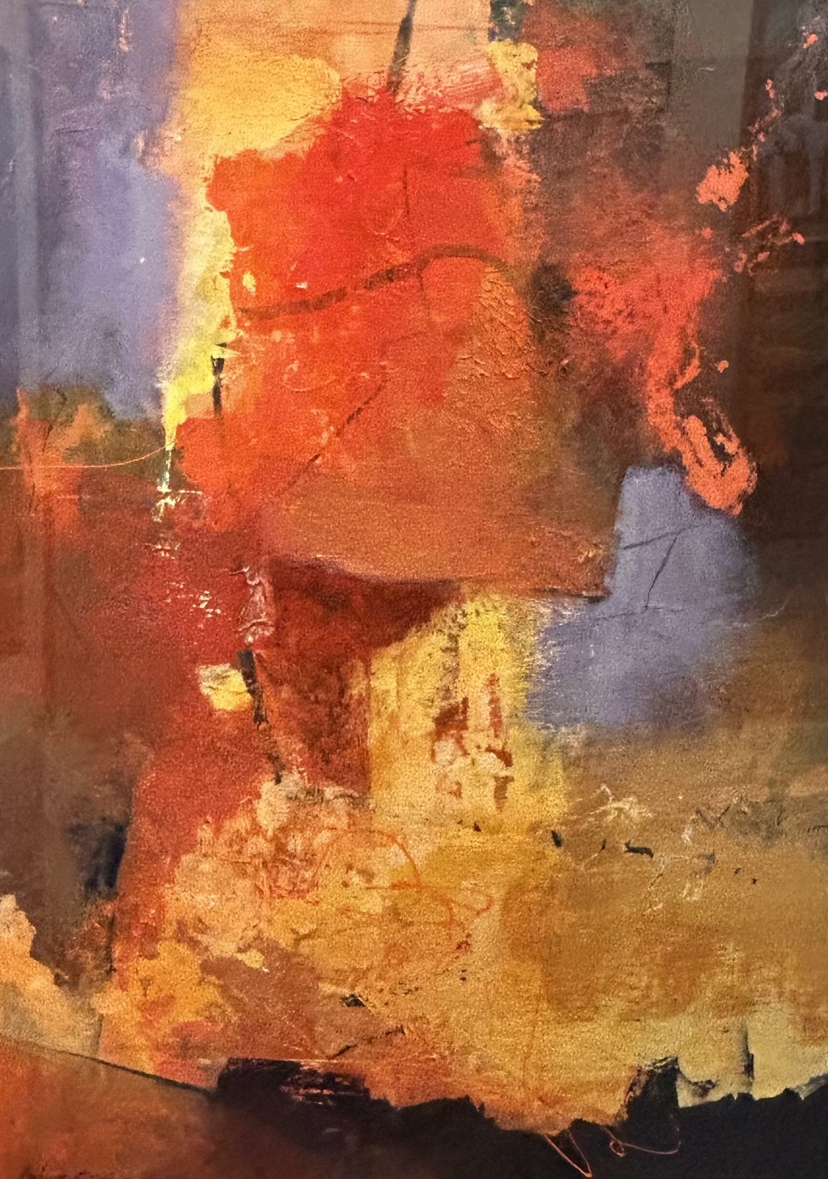 Close-up of a colorful abstract painting with dominant red, orange, and purple hues, textured surface, and visible brushstrokes.