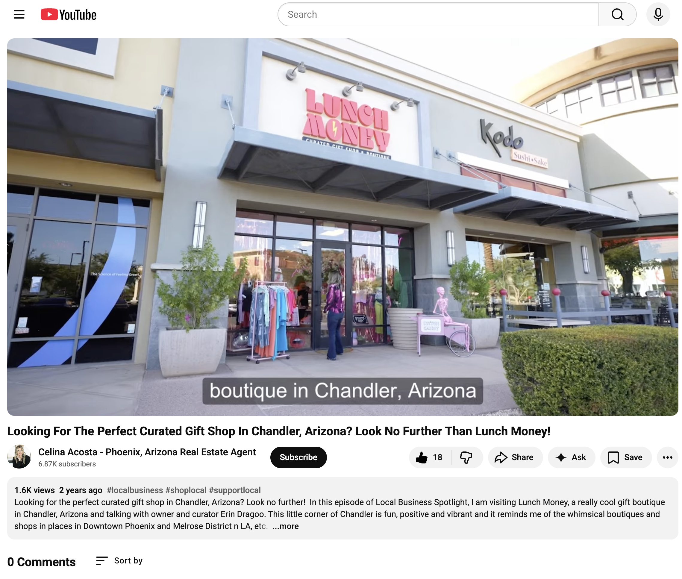 Exterior view of a boutique gift shop named Lunch Money in Chandler, Arizona, with display clothing outside and a pink bicycle sculpture nearby.