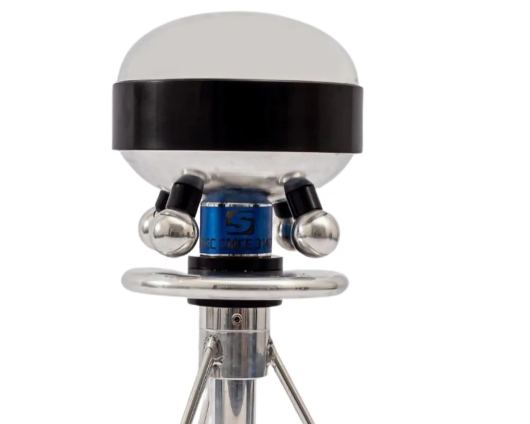 A modern handheld barcode scanner with a white and black design, mounted on a tripod stand.