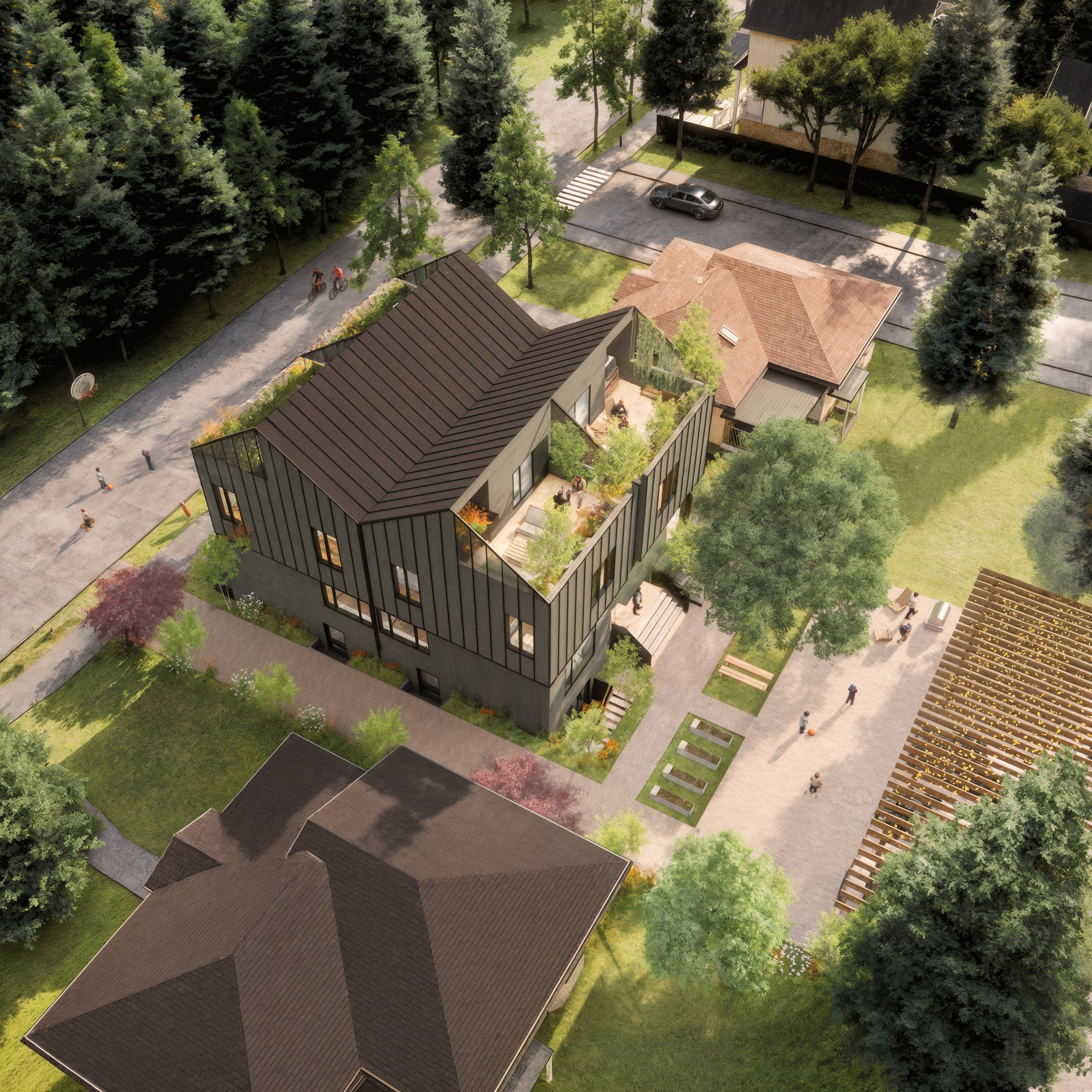 Aerial view of a modern multi-story building with rooftop gardens, surrounded by trees, pathways, and neighboring houses with diverse roofing styles in a suburban area.
