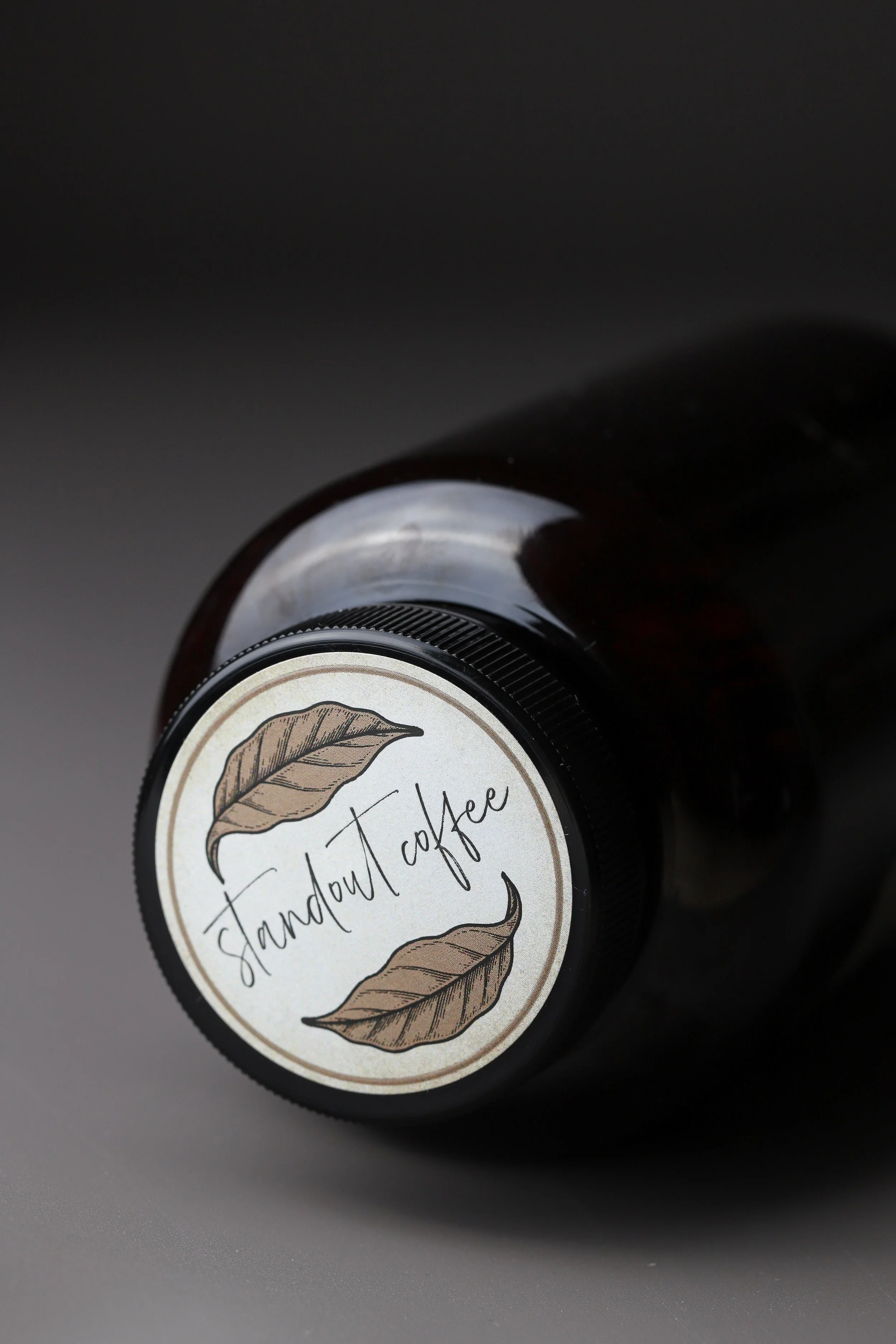 Brown bottle with 'standout coffee' label featuring leaf illustrations.