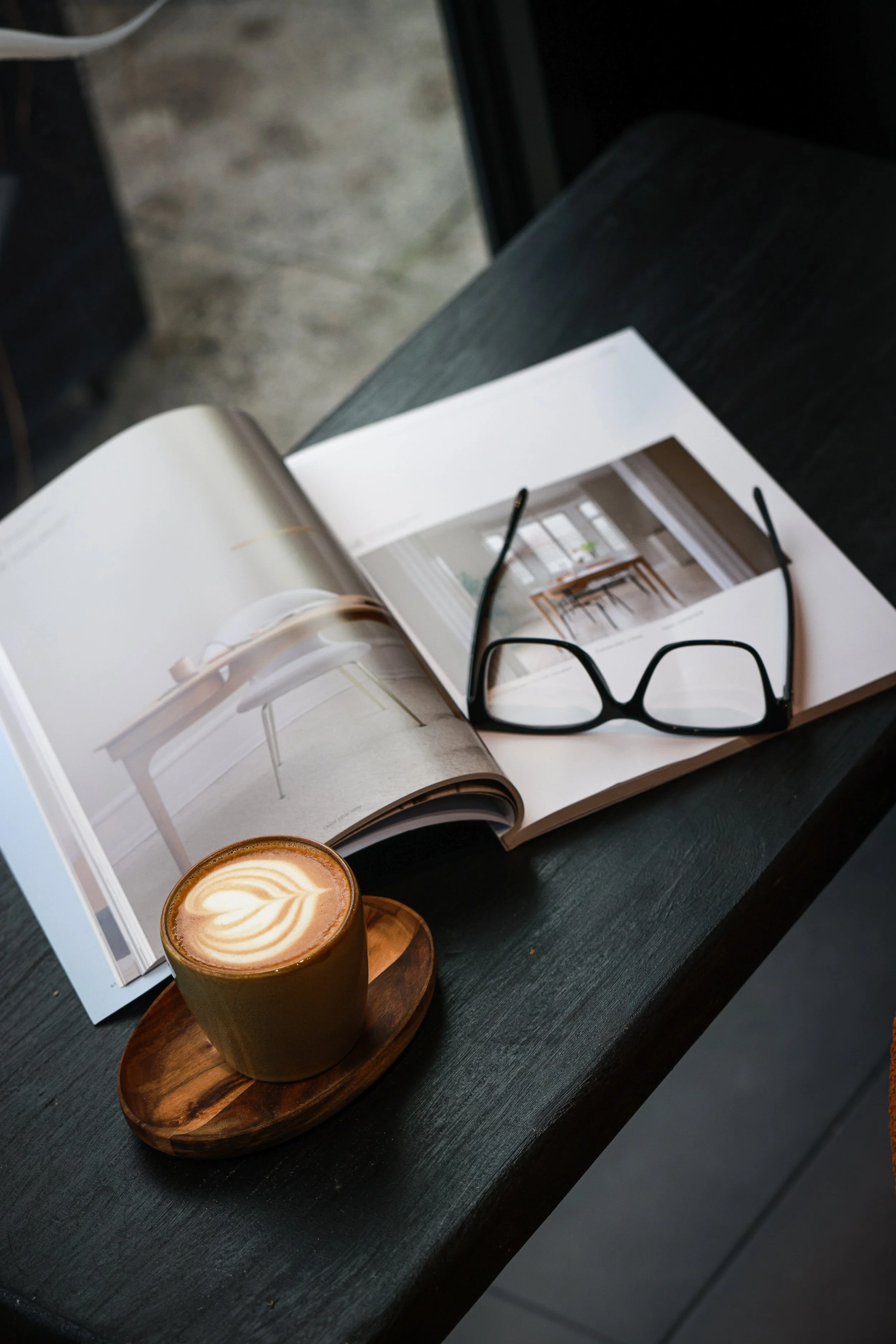 Close-up of a white ceramic cup filled with espresso on a wooden surface.