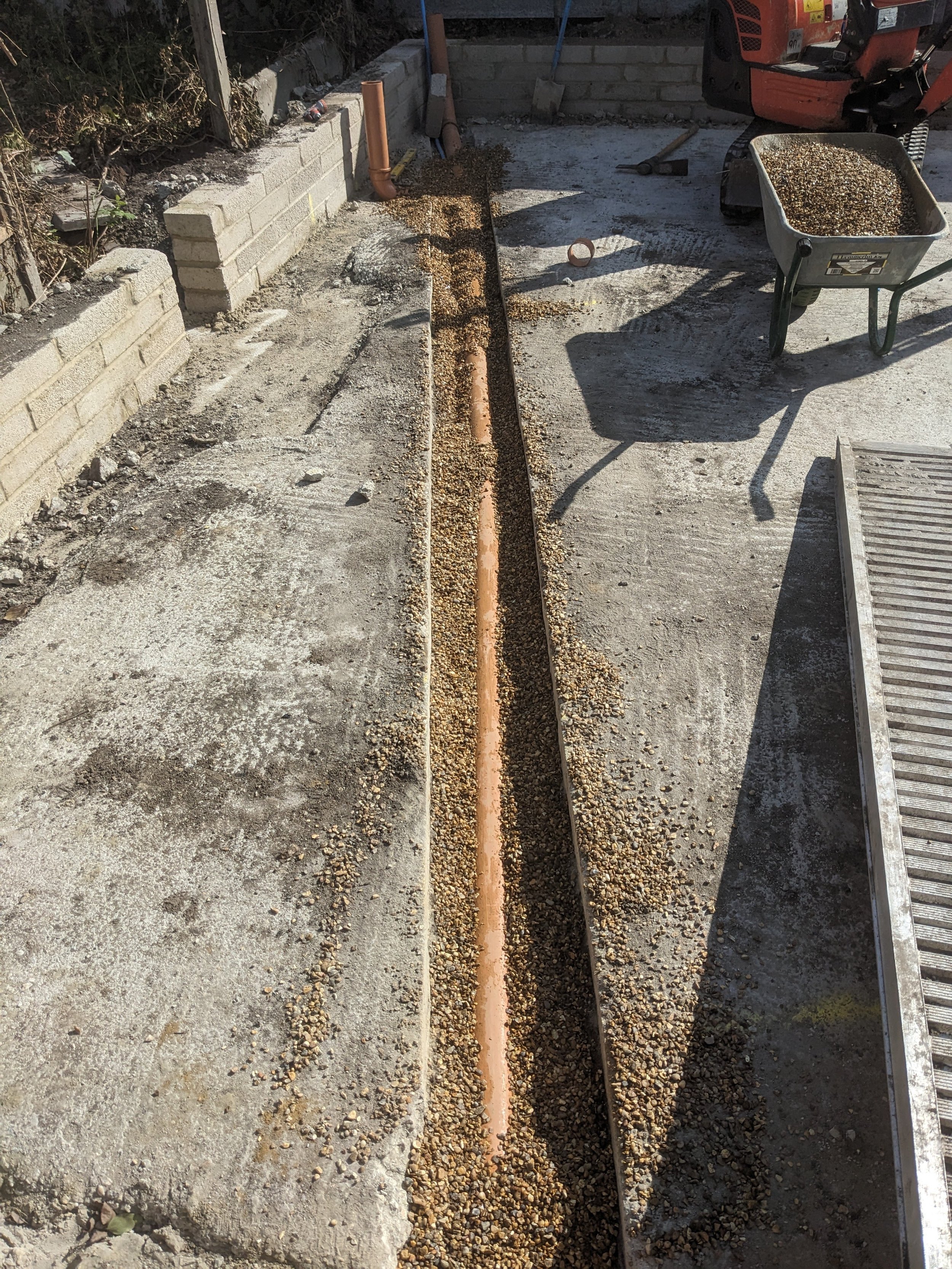 underground drainage being installed through concrete slab for garden building in leyton