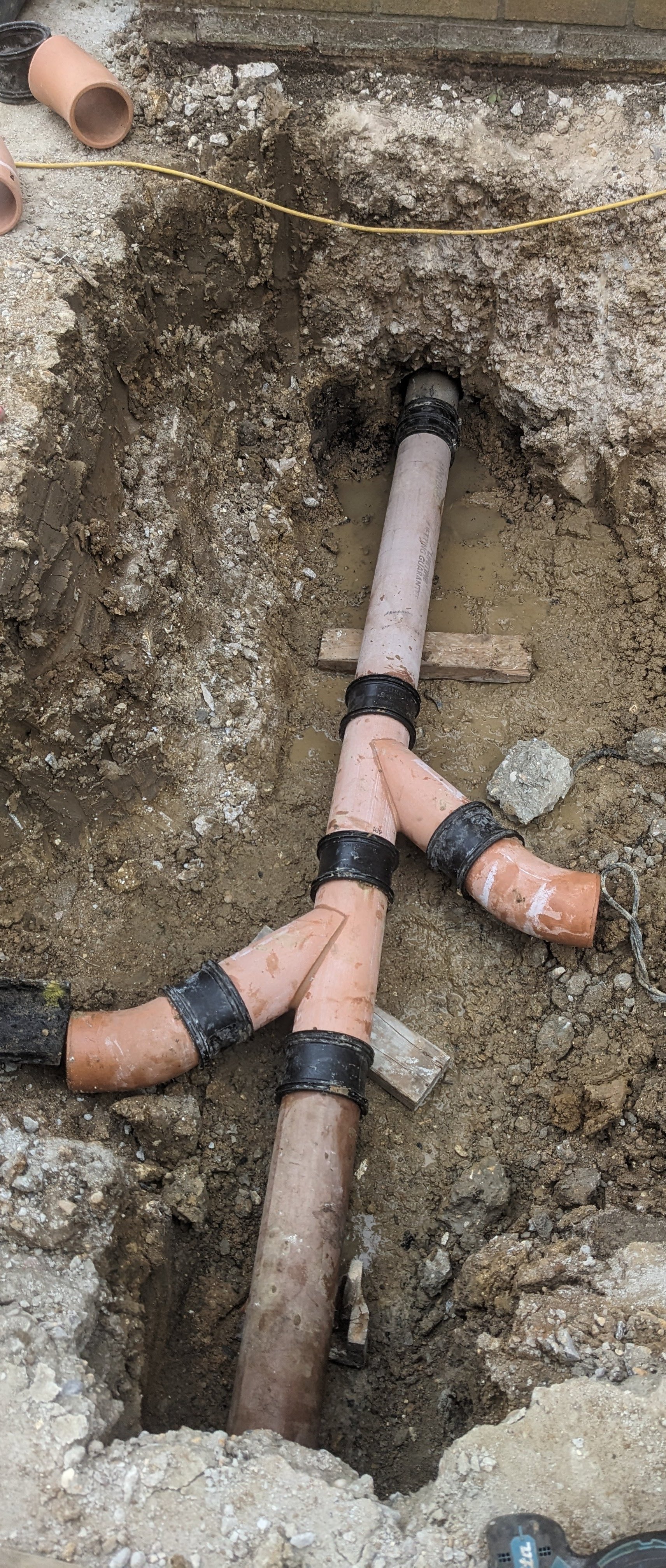 underground clay drainage being installed to replace manhole for extension in essex