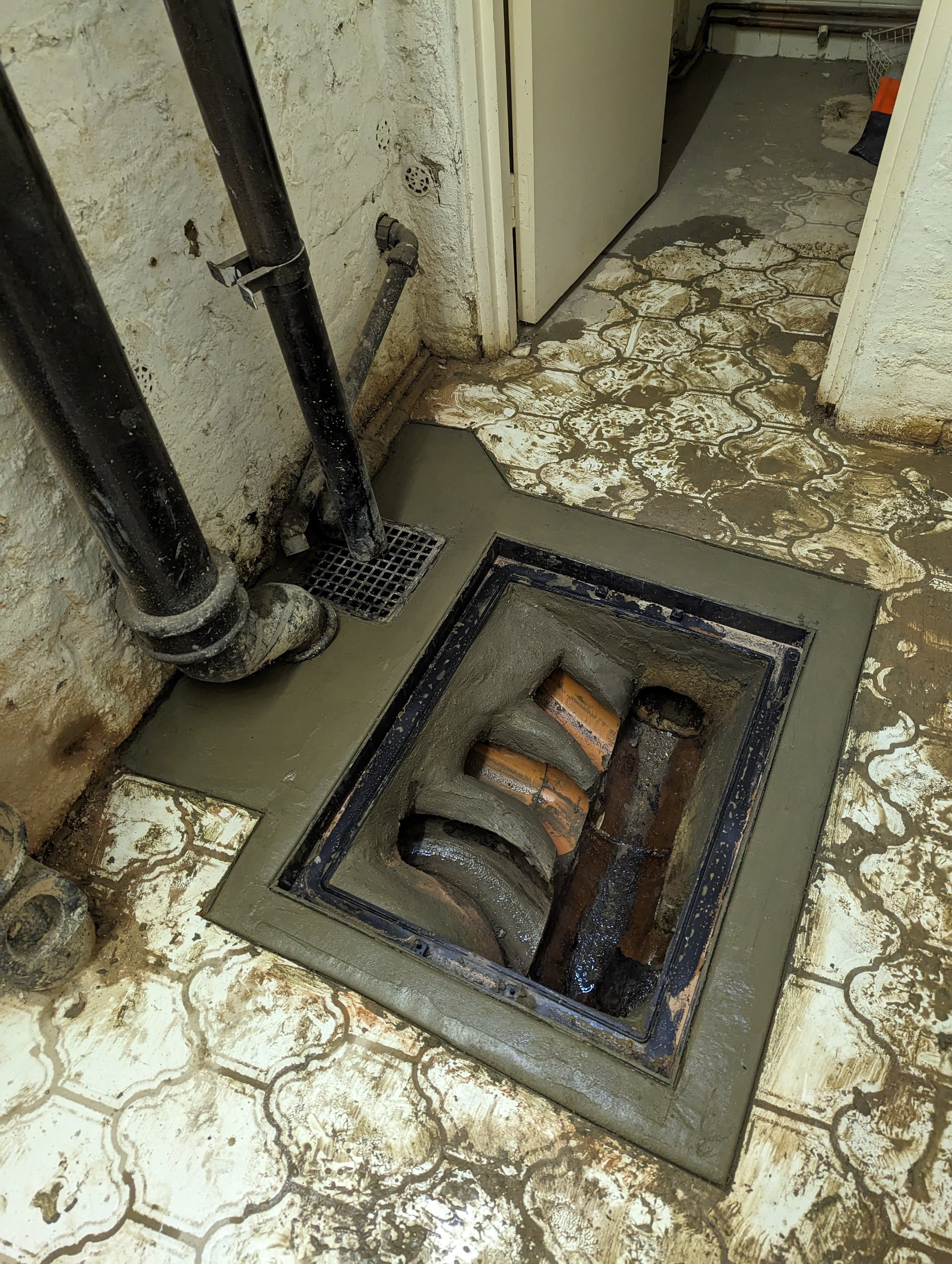 manhole partially removed to repair damaged pipework in basement in marylebone