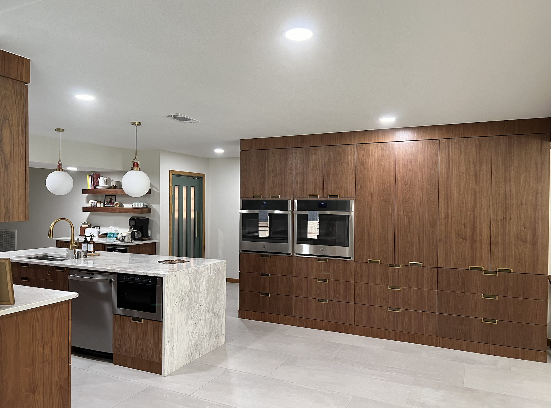 Large spacious kitchen remodel with double ovens, maximum storage with custom woods cabinets and a large quartz waterfall island