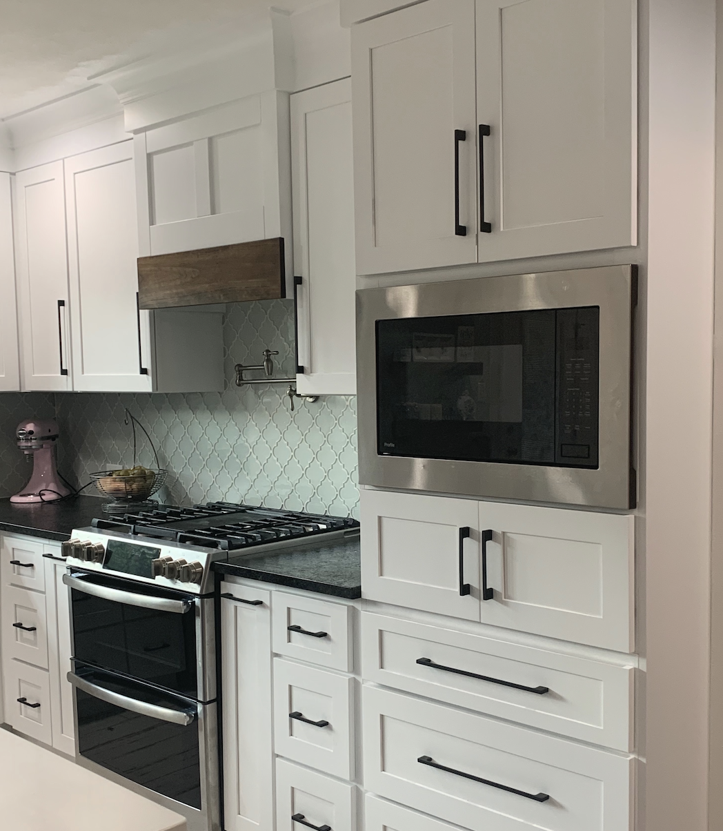 White custom shaker cabinets with upgraded stainless steel appliances in a modern kitchen renovation.