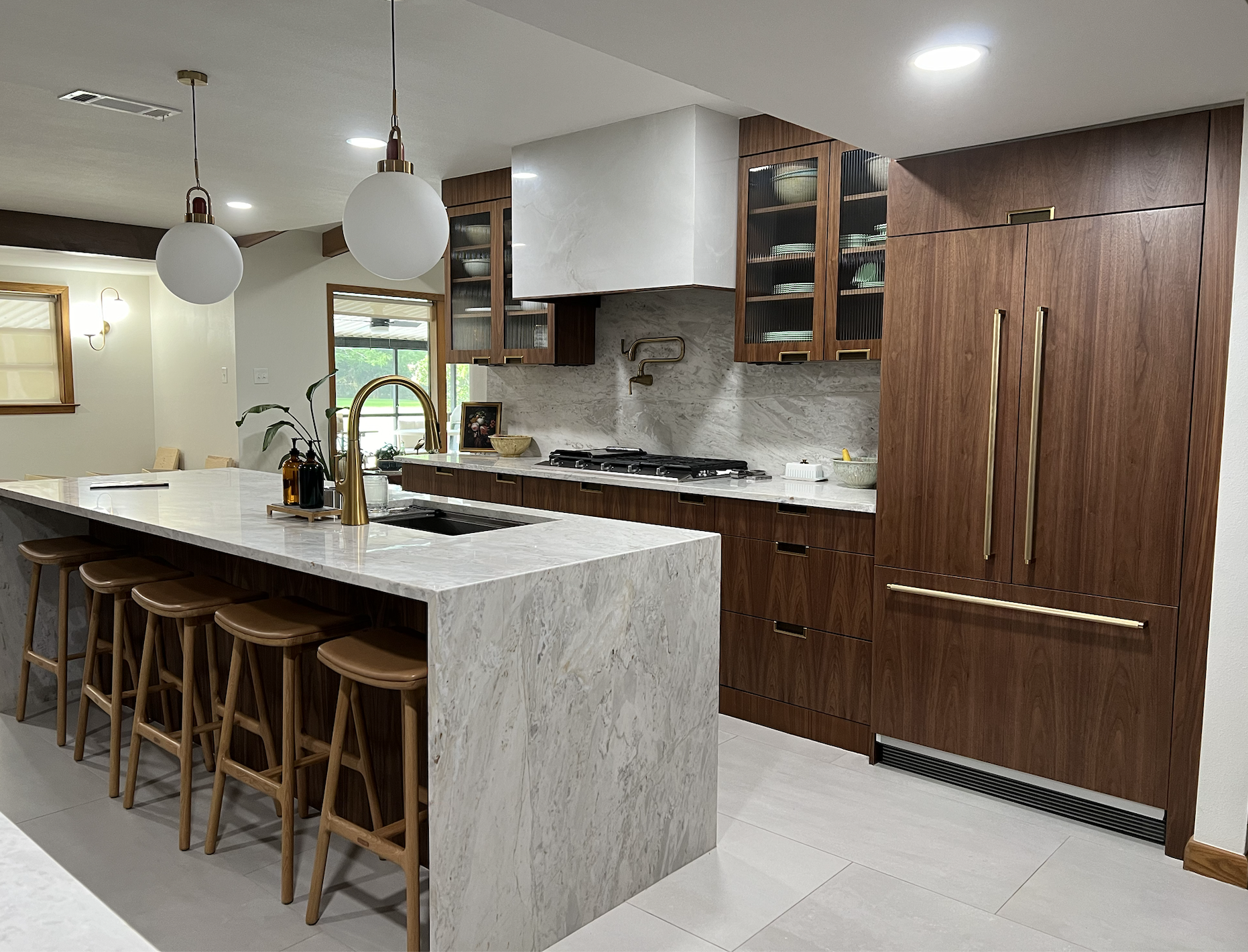 Open-concept kitchen renovation with light wood cabinetry and large waterfall island