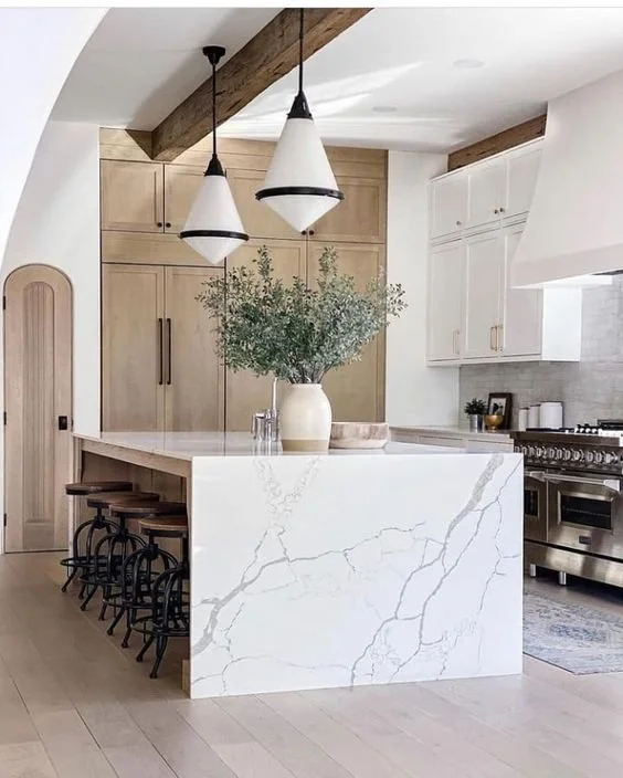 Custom countertops with a luxurious marble and quartz waterfall kitchen island, adding sophistication and durability to the space.